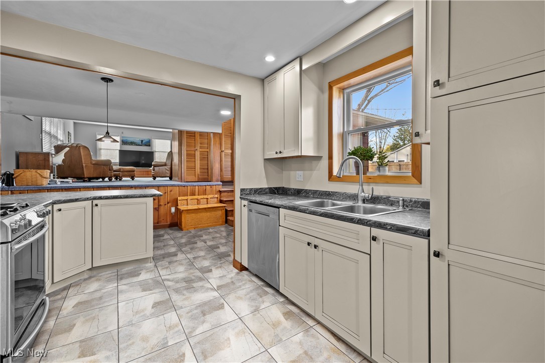 958 West River Road Vermilion, OH 44089 - Photo 17 of 40 Kitchen featuring pendant lighting, light tile patterned flooring, sink, and appliances with stainless steel finishes