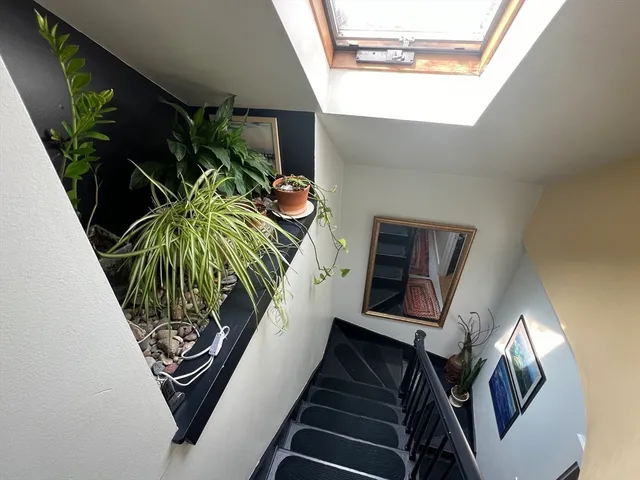 a view of a hallway with wooden floor and stairs
