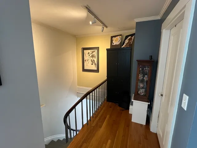 a view of a hallway with wooden floor and staircase