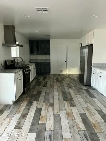 a kitchen with granite countertop a sink cabinets and stainless steel appliances