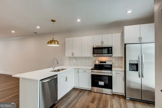 a kitchen with a refrigerator a sink and a stove top oven