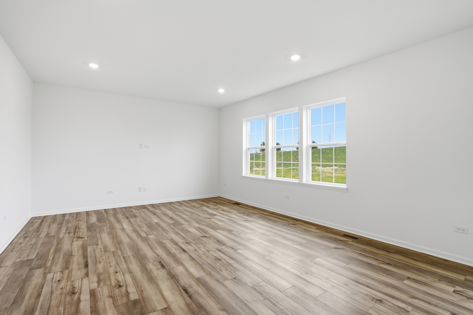 357 Danforth Drive Oswego, IL 60543 - Photo 5 of 22 an empty room with wooden floor and windows