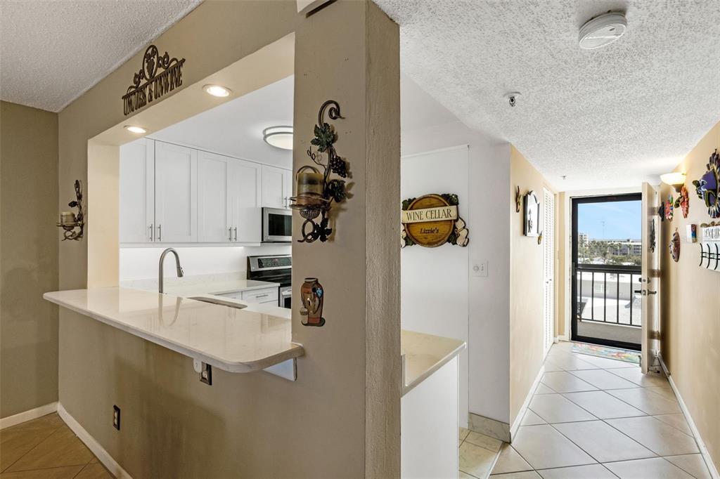 14900 Gulf Boulevard, Unit 410 Madeira Beach, FL 33708 - Photo 34 of 76 a kitchen with stainless steel appliances granite countertop a refrigerator and a sink
