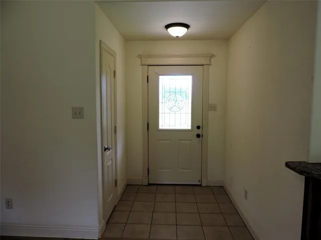 a view of a hallway with wooden floor and a bathroom
