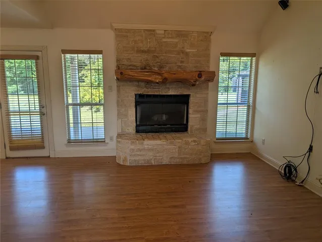 wooden floor fireplace and windows in an empty room