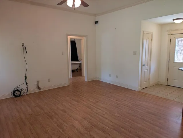 a view of an empty room with window and wooden floor