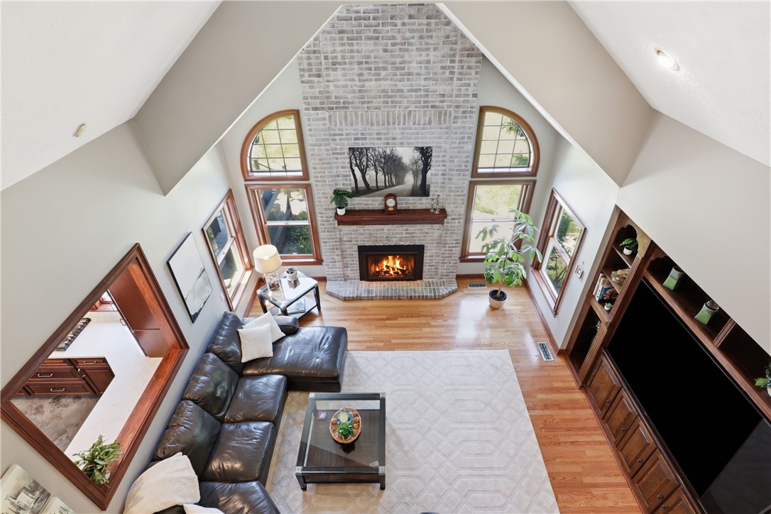 2057 Stirnie Road Victor, NY 14564 - Photo 21 of 48 This dramatic second-floor perspective showcases the true grandeur of the living room, framing the floor-to-ceiling brick wood-burning fireplace and custom-crafted built-in cabinetry