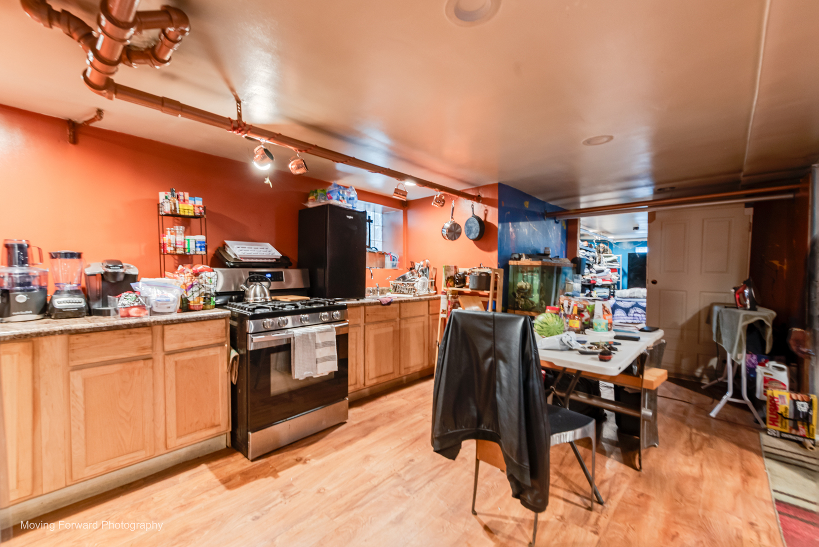 8213 South Indiana Avenue Chicago, IL 60619 - Photo 22 of 25 a kitchen with stainless steel appliances kitchen island granite countertop a table chairs in it and wooden floors