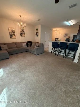 a living room with furniture and a chandelier