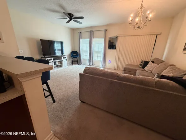 a living room with furniture a flat screen tv and a window