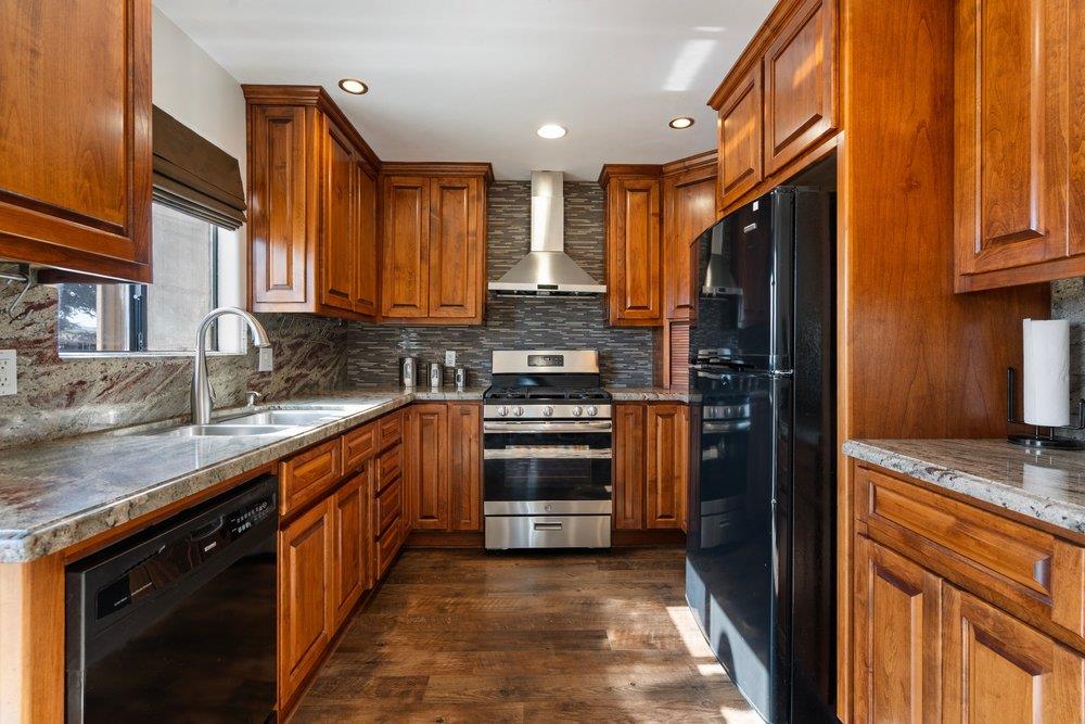 a kitchen with stainless steel appliances granite countertop a stove and a refrigerator