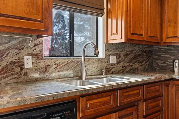 a kitchen with granite countertop a sink and a window