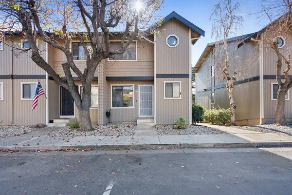 a view of a house with a tree in front of it