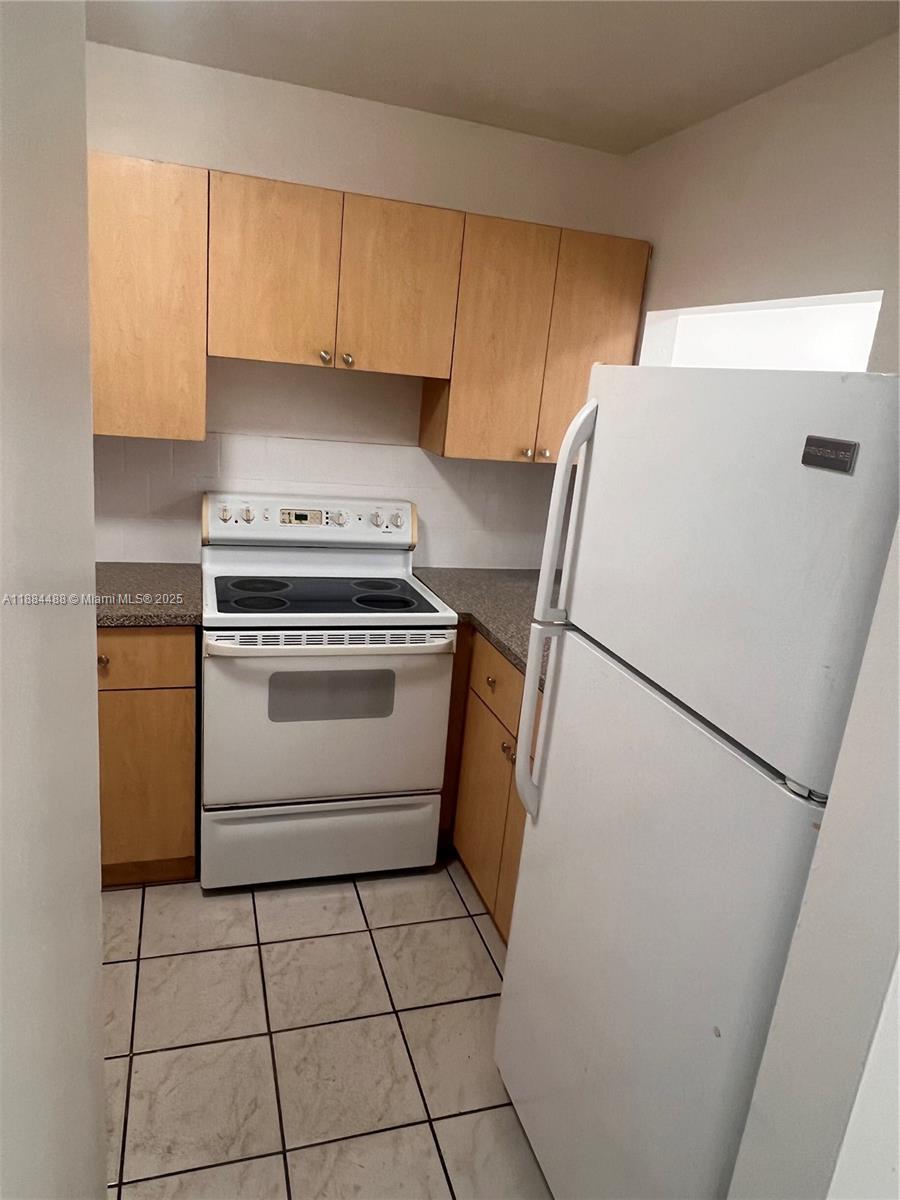 10851 Southwest 2nd Street, Unit K304 Sweetwater, FL 33174 - Photo 8 of 16 a kitchen with a stove a refrigerator and a sink