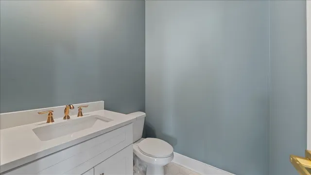 a bathroom with a toilet sink vanity and mirror