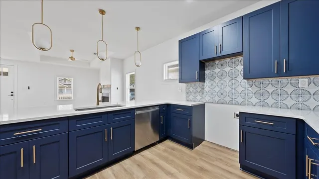 a kitchen with stainless steel appliances granite countertop a sink a stove and cabinets