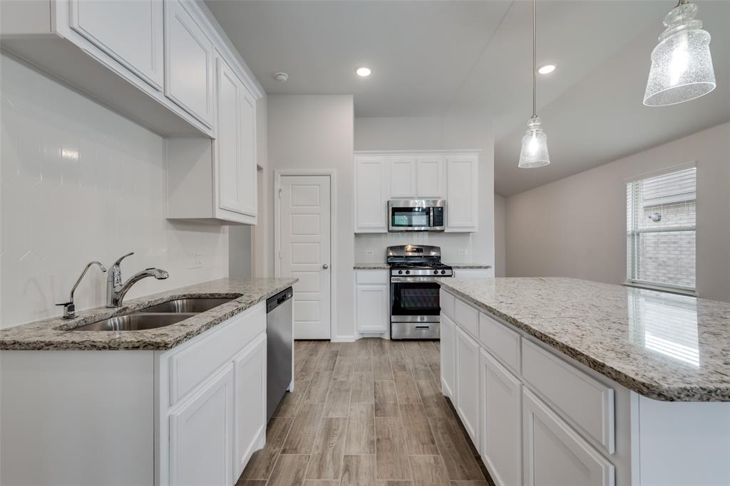 1137 Catalan Trail Mesquite, TX 75149 - Photo 11 of 22 a kitchen with kitchen island granite countertop a sink stove and refrigerator