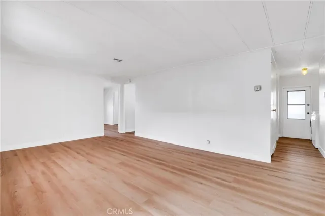 an empty room with a wooden floor and windows