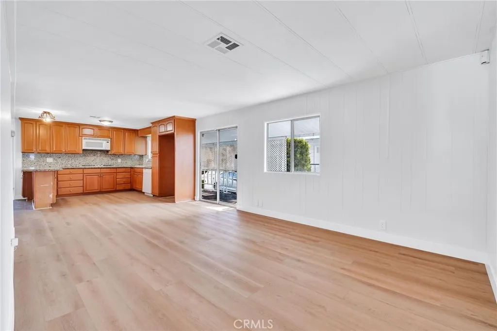 17700 Avalon, Unit 267 Carson, CA 90745 - Photo 22 of 50 an empty room with a wooden floor and windows