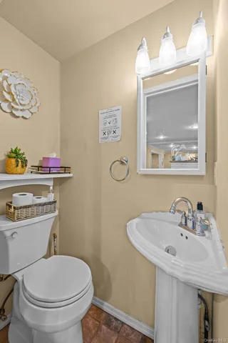 a bathroom with a toilet sink and mirror