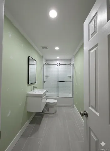 a bathroom with a toilet a sink and mirror