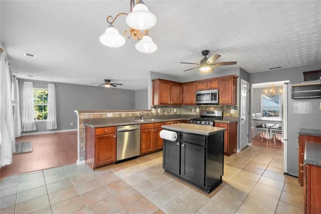 a kitchen with stainless steel appliances granite countertop a stove a sink dishwasher and a refrigerator
