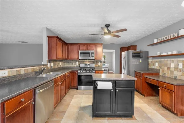 a kitchen with stainless steel appliances granite countertop a stove a sink dishwasher a refrigerator and a microwave oven