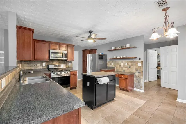 a kitchen with stainless steel appliances granite countertop a stove oven and a refrigerator