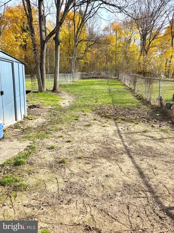 a view of a backyard with wooden fence