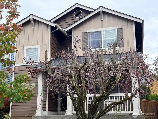 a front view of house with yard and trees in the background