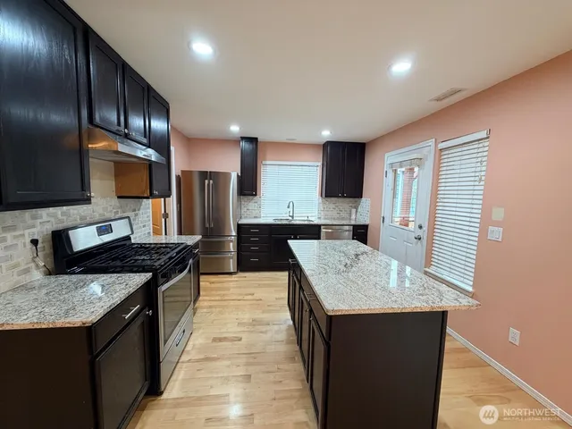 a kitchen with granite countertop stainless steel appliances and sink