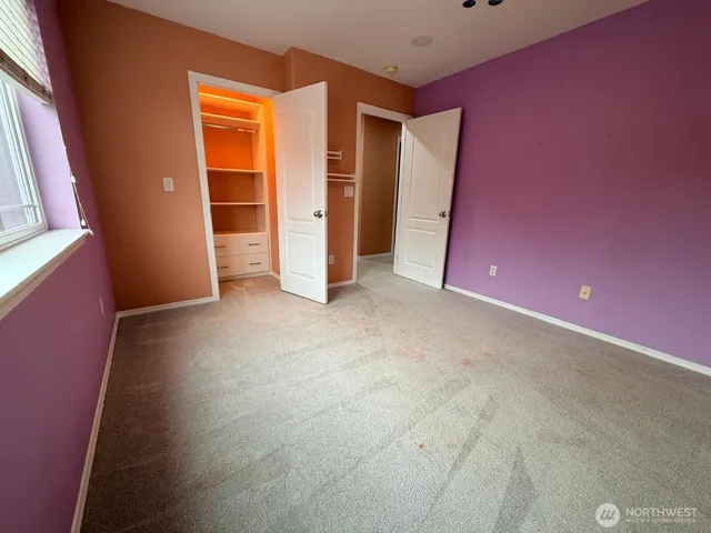 an empty room with closet and a window