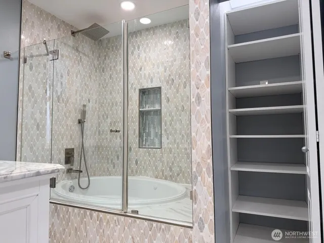 a bathroom with a granite countertop sink and shower