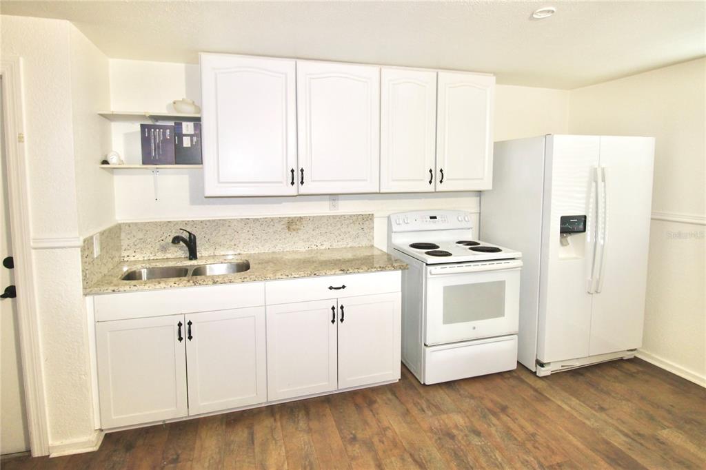 608 Dundee Road Dundee, FL 33838 - Photo 53 of 77 a kitchen with granite countertop white cabinets and white appliances