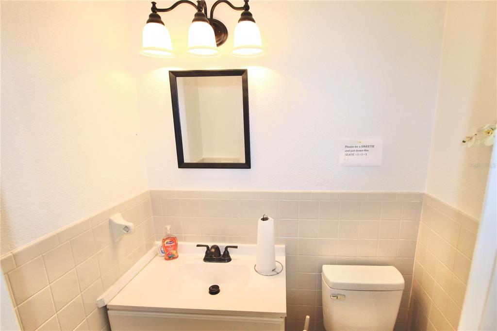 608 Dundee Road Dundee, FL 33838 - Photo 63 of 77 a bathroom with a toilet sink vanity and mirror