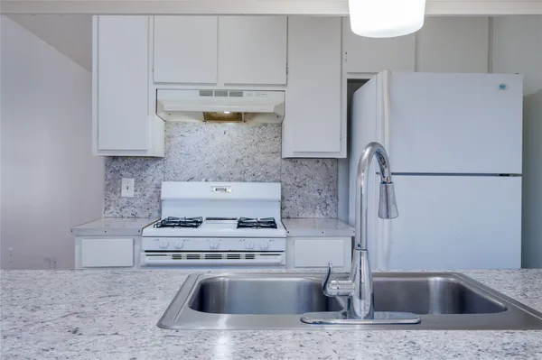 a kitchen with a refrigerator sink stove and cabinets