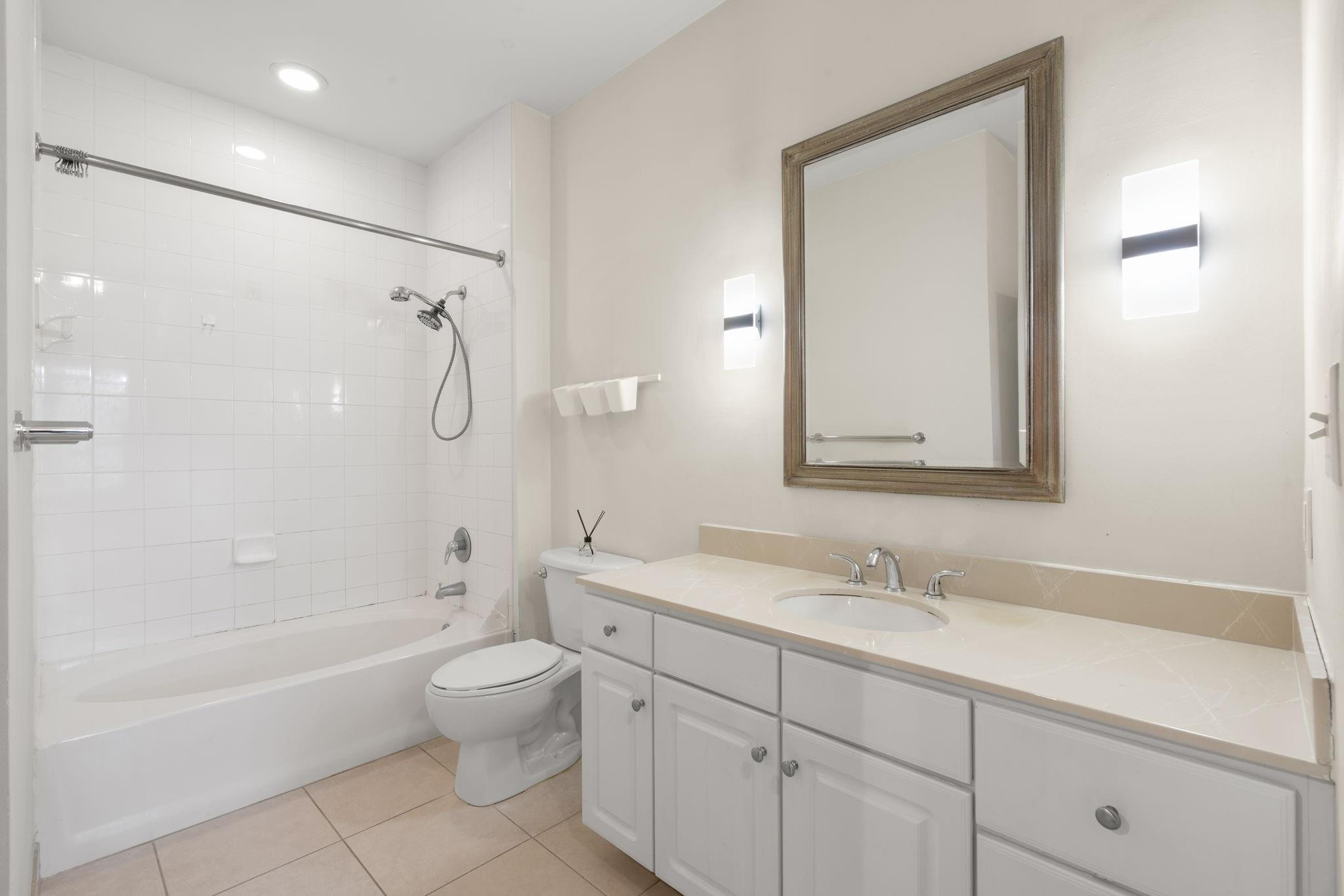 2001 Biscayne Boulevard, Unit 2303 Miami, FL 33137 - Photo 19 of 36 a bathroom with a toilet a sink a mirror a bathtub and vanity