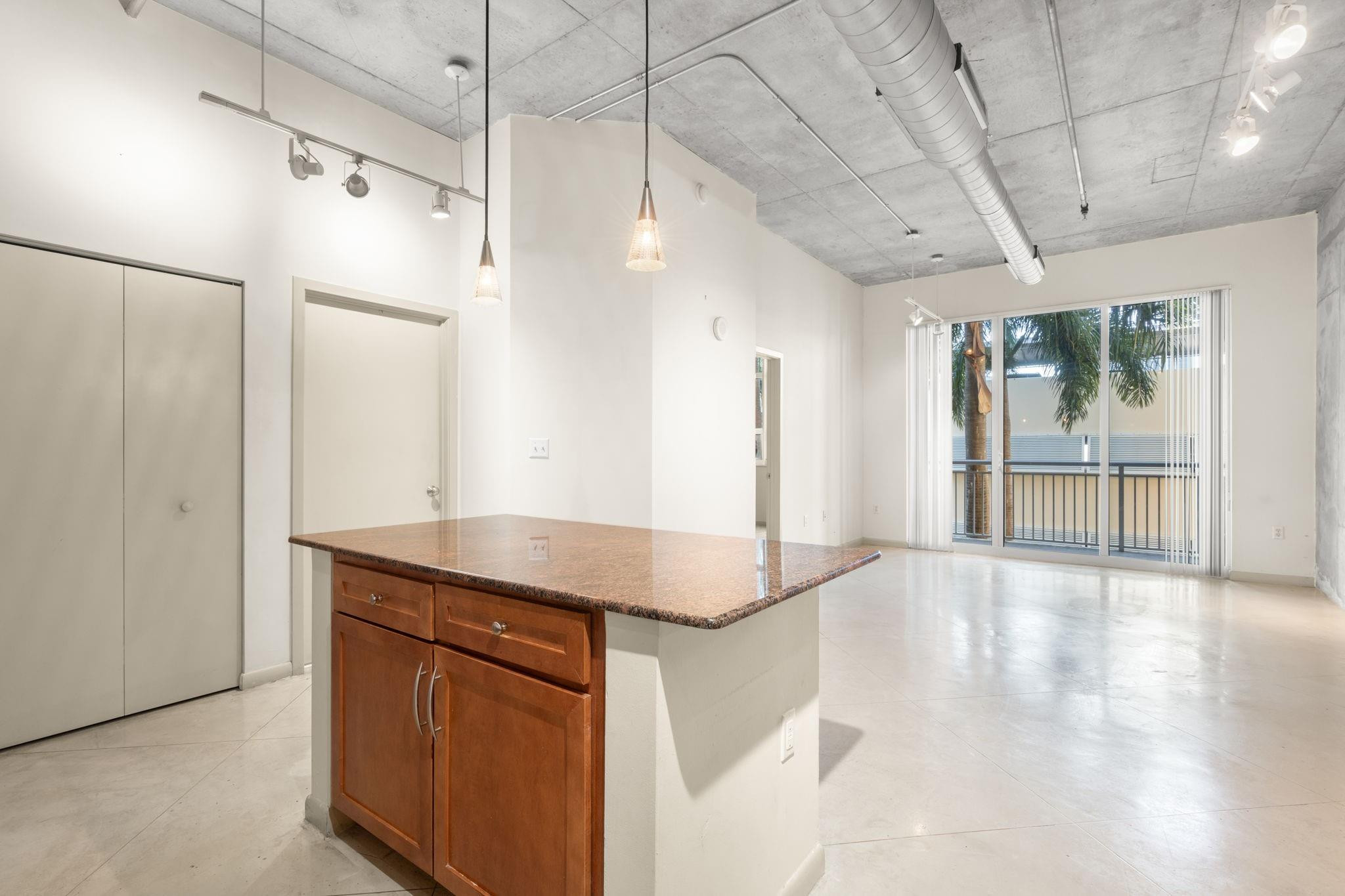 2001 Biscayne Boulevard, Unit 2303 Miami, FL 33137 - Photo 10 of 36 a bathroom with a granite countertop sink a shower and a mirror