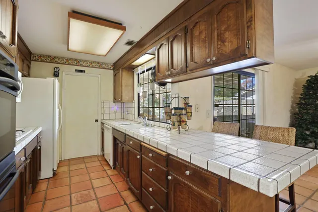 a kitchen with stainless steel appliances granite countertop a sink stove and cabinets