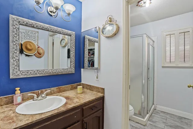 a bathroom with a granite countertop sink and a mirror
