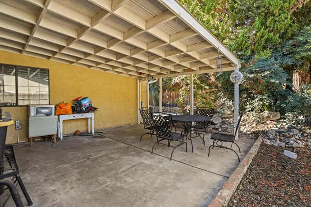 a view of a patio with table and chairs and potted plants