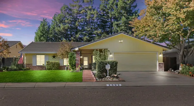a front view of a house with a yard and potted plants