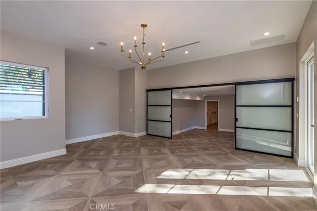 a kitchen with a white wooden cabinets and window
