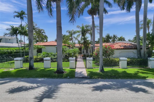 an aerial view of ocean and residential houses with outdoor space