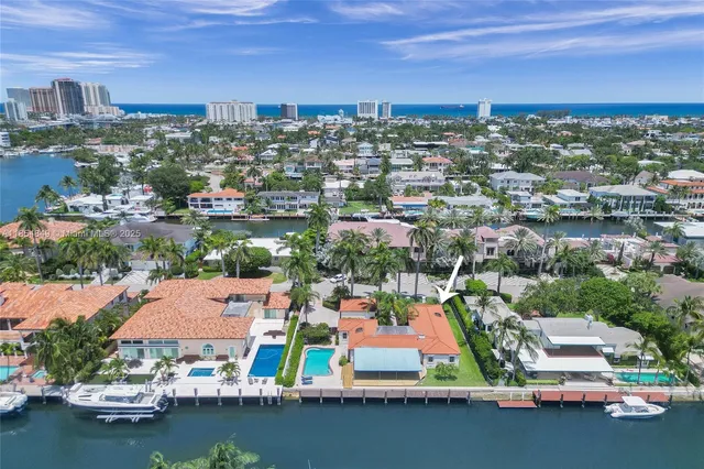an aerial view of a city with lots of residential buildings ocean and mountain view in back