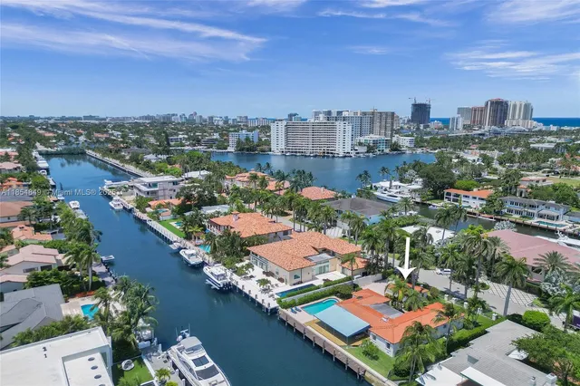 an aerial view of a city with lots of residential buildings ocean and mountain view in back