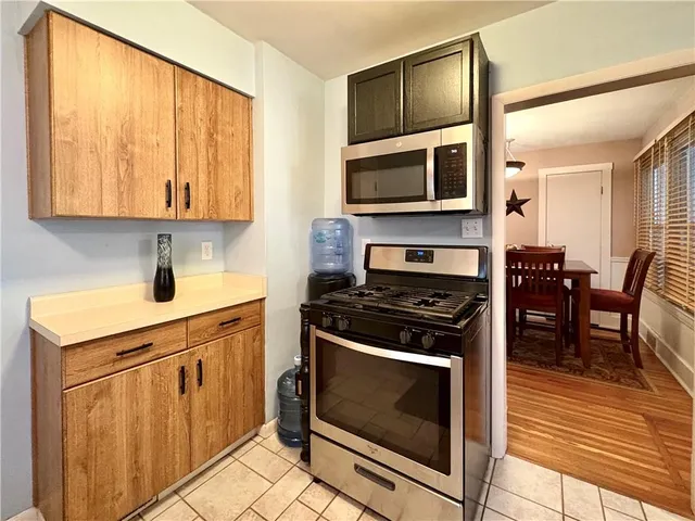 a kitchen with stainless steel appliances a stove a sink and white cabinets