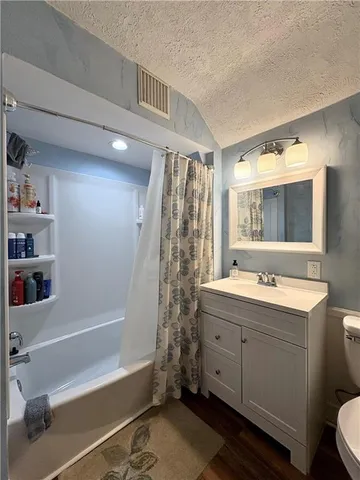 a bathroom with a double vanity sink toilet and shower