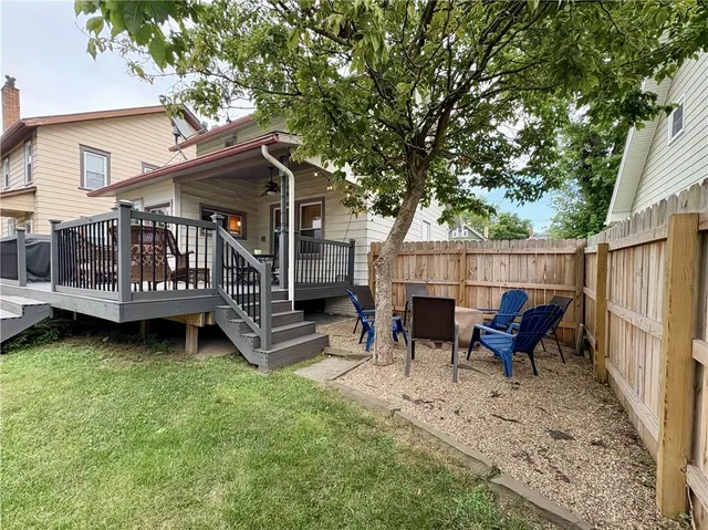 a view of a house with a backyard and wooden fence