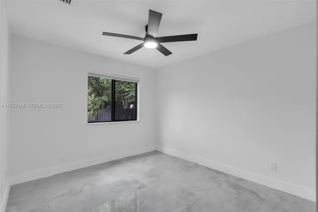 an empty room with chandelier fan